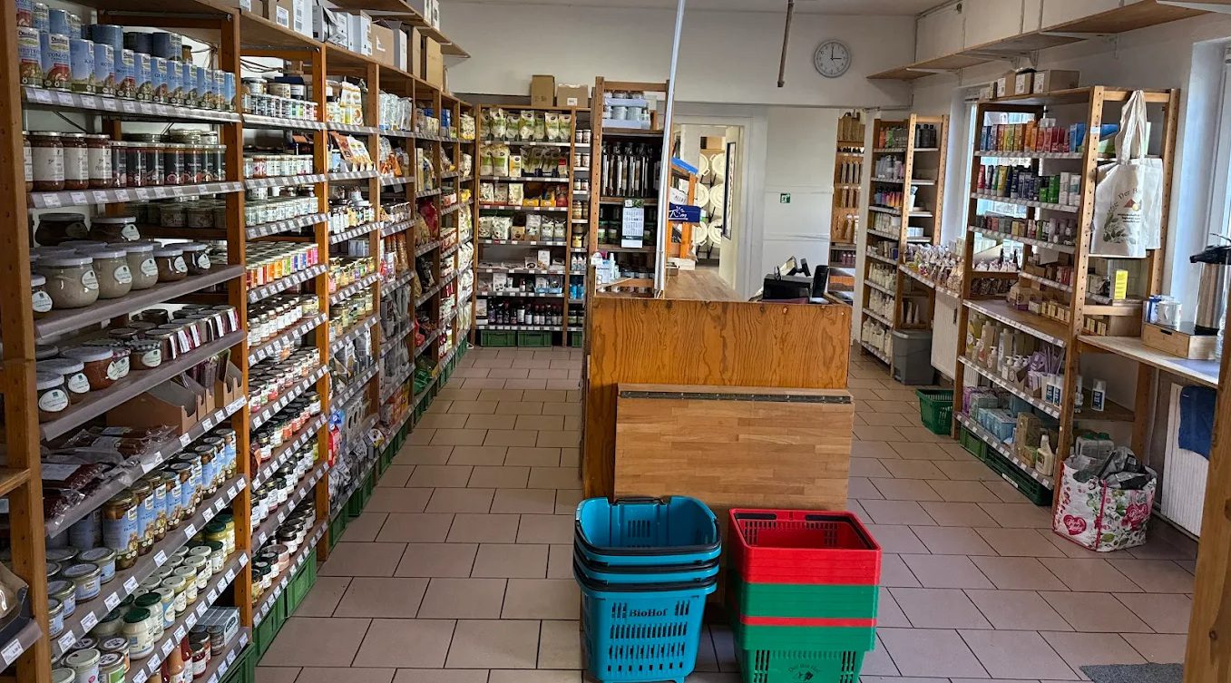 Innenansicht des BioHof-Mitgliederladens in Kiel mit Holzregalen voller regionaler Bioprodukte und gemütlicher Atmosphäre.