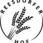 reesdorfer Logo von „Joldelunder Bio-Backspezialitäten“ in ovaler Form: dunkelblauer Schriftzug „Joldelunder“, darunter grün-blau „Bio-Backspezialitäten“, links davon stilisierte grüne Ähre, eingefaßt von einem hellblauen Ovalsrahmen.